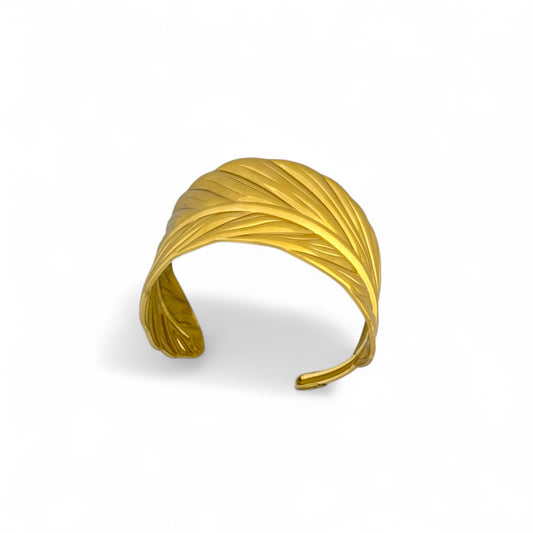 Gold-tone cuff bracelet with sculpted palm-leaf groove texture.