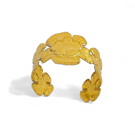 Open gold cuff bracelet featuring an overlapping floral design in polished stainless steel.