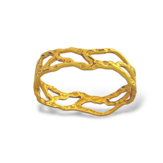 Gold-tone stainless steel bangle with vine-inspired openwork design and adjustable cuff fit.